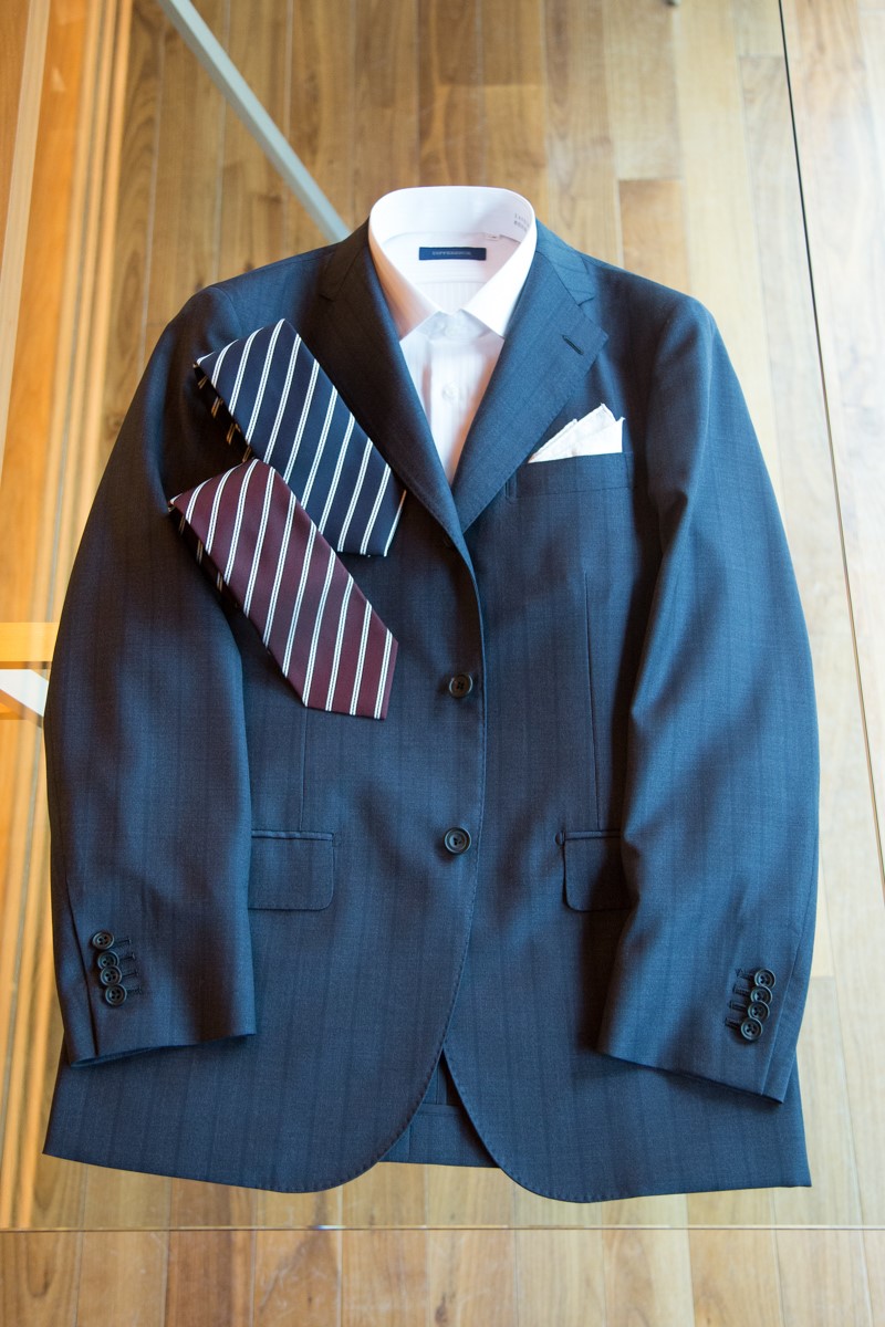 ビジネス・カジュアルシーンのブラックスーツにストライプ柄のネクタイ