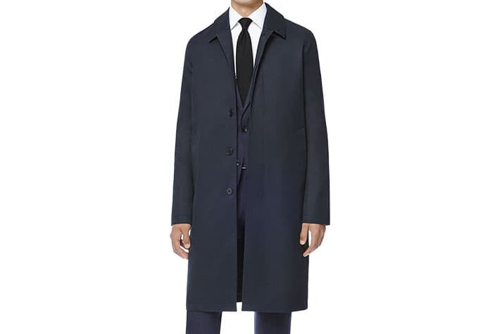 スーツにステンカラーコートを着用した男性